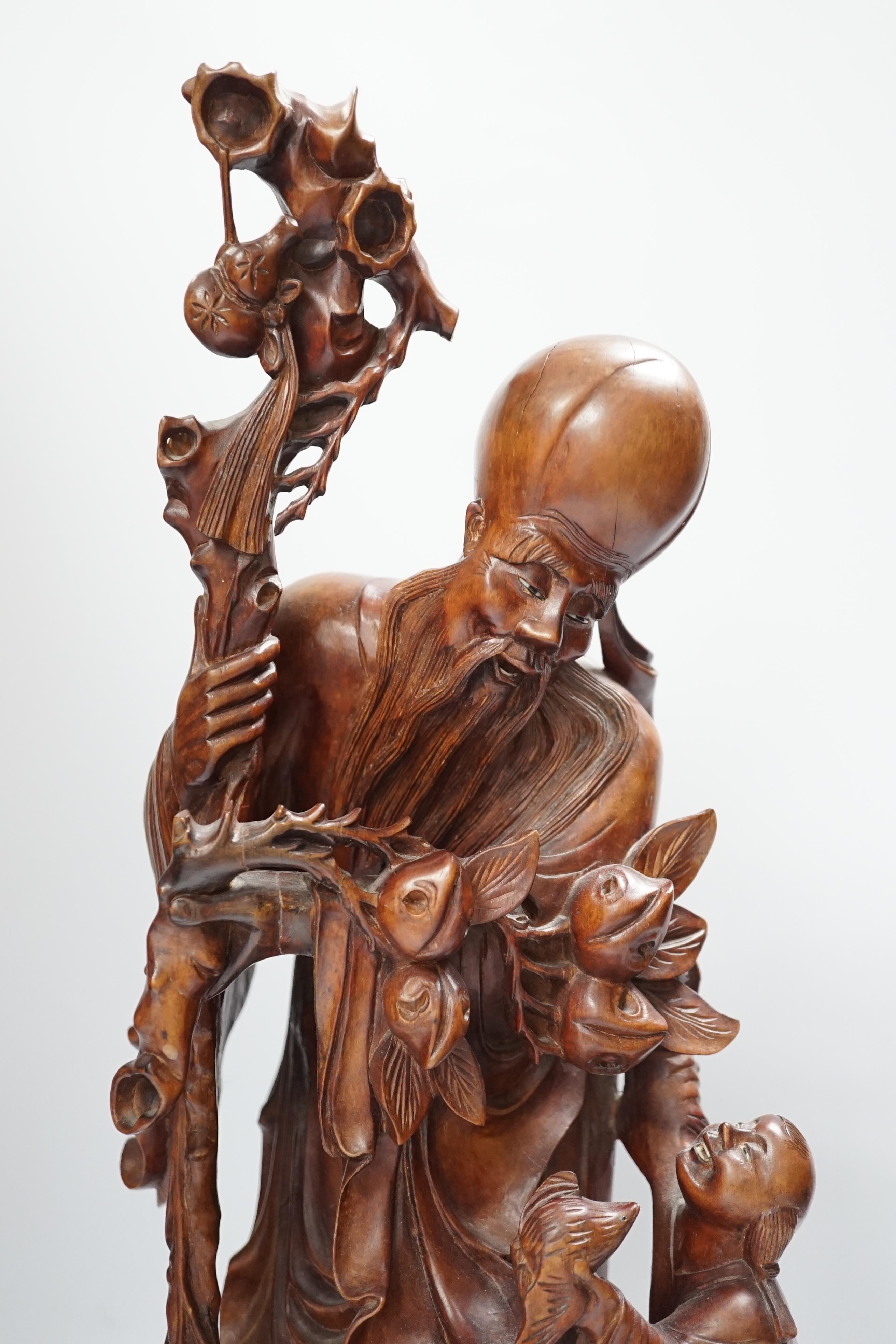 A large Chinese carved wooden figure group of Shou Lao and a pair of small carved figures, figure group 52cm high
